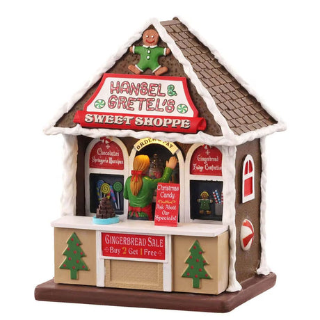 Casetta natalizia Hansel & Gretel's Sweet Shoppe per la vendita di dolciumi con insegna rossa.