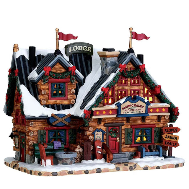 Chalet di montagna innevato con decorazioni natalizi e insegna “Snow Chalet Mountain Lodge”.