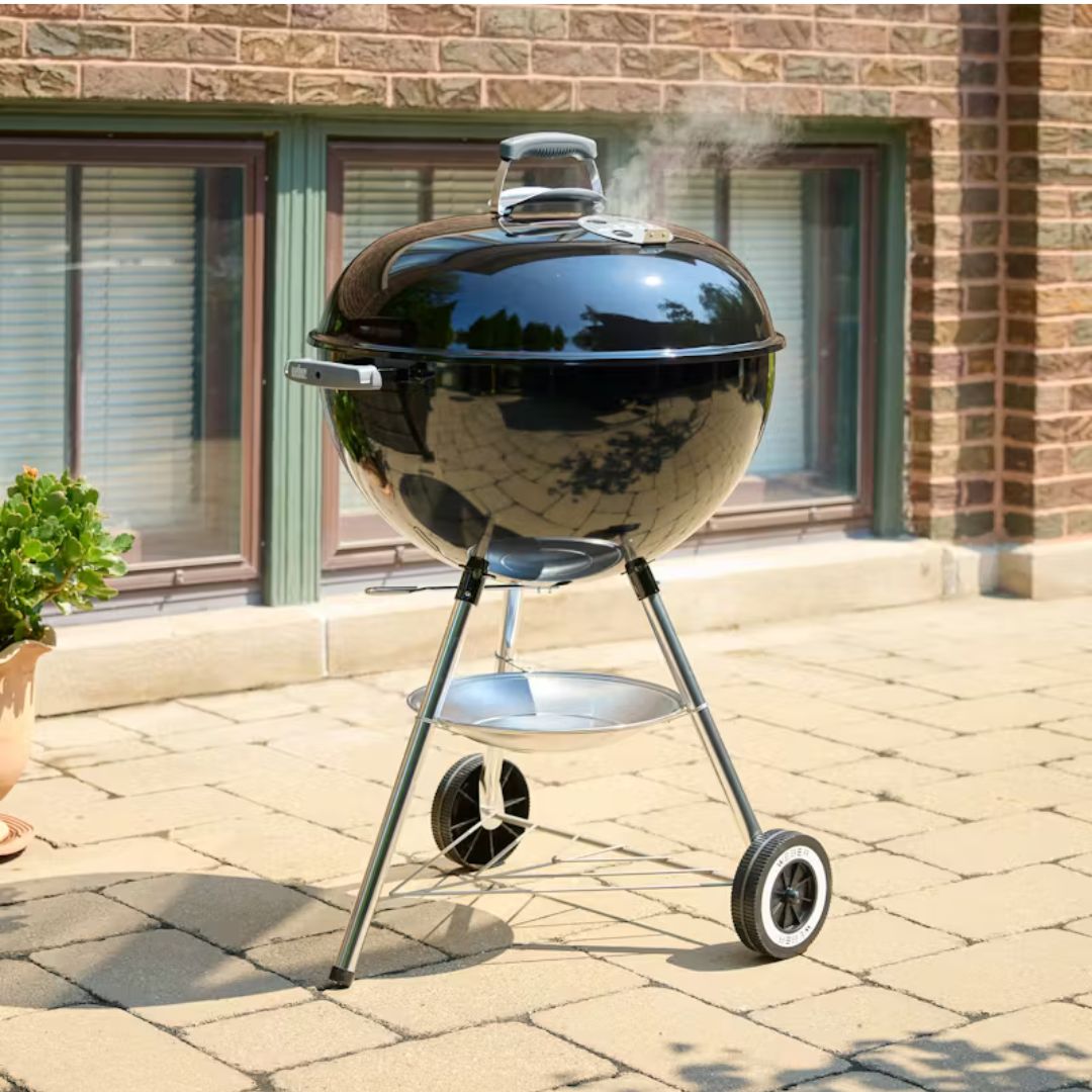 Barbecue a carbone Weber Original Kettle nero posizionato su una pavimentazione esterna