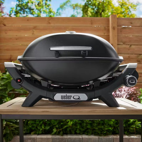 Barbecue a gas Weber Q 2100 nero appoggiato su un tavolo da esterno