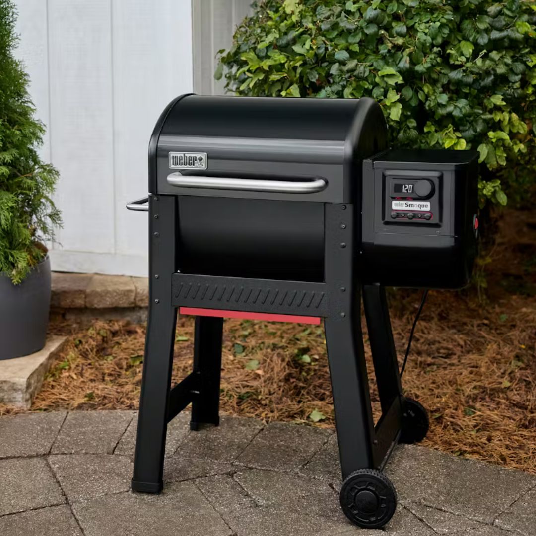 Barbecue a pellet Weber Smoque nero posizionato su una pavimentazione esterna