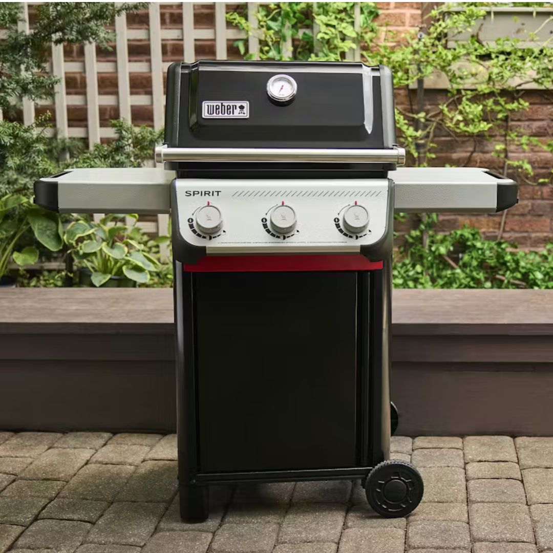 Barbecue a gas Weber Spirit E-310 nero posizionato su una pavimentazione esterna