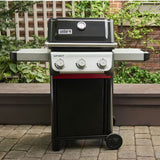 Barbecue a gas Weber Spirit E-310 nero posizionato su una pavimentazione esterna