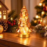 Alberello luminoso in vetro ambra ambientato con rami e luci di Natale