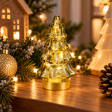 Alberello luminoso in vetro verde ambientato tra decorazioni natalizie