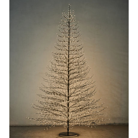Albero decorativo natalizio alto 300cm con rami sottili illuminato da micro LED bianco caldo.