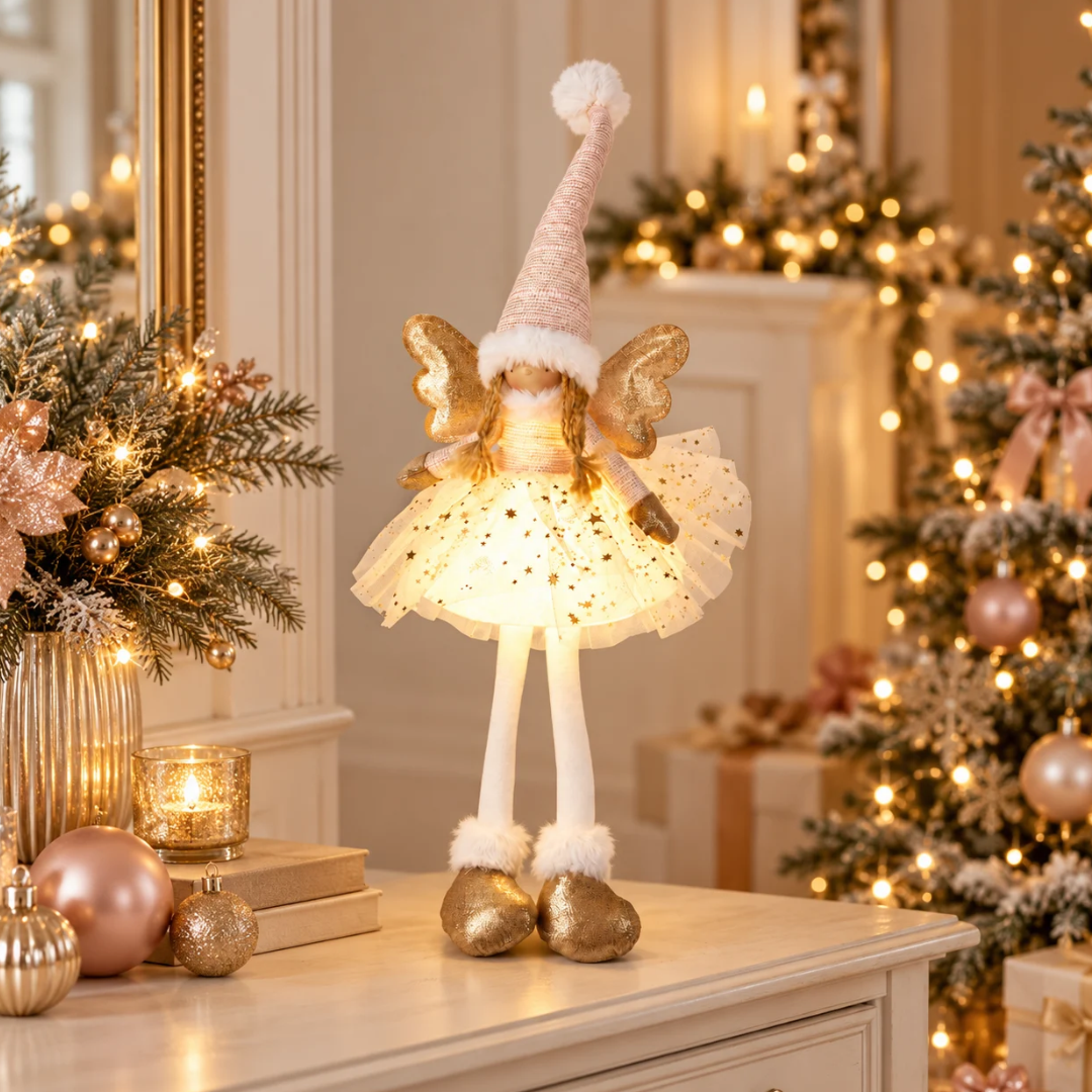 Angelo decorativo rosa e oro illuminato, ambientato tra albero di Natale e addobbi dai toni caldi