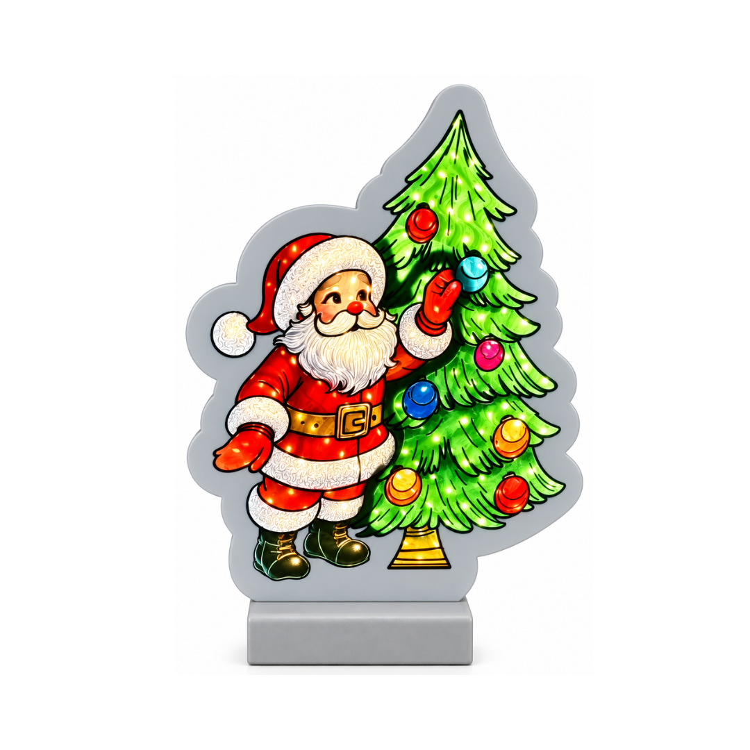 Decorazione luminosa natalizia con Babbo Natale accanto a un albero di Natale verde addobbato con palline colorate
