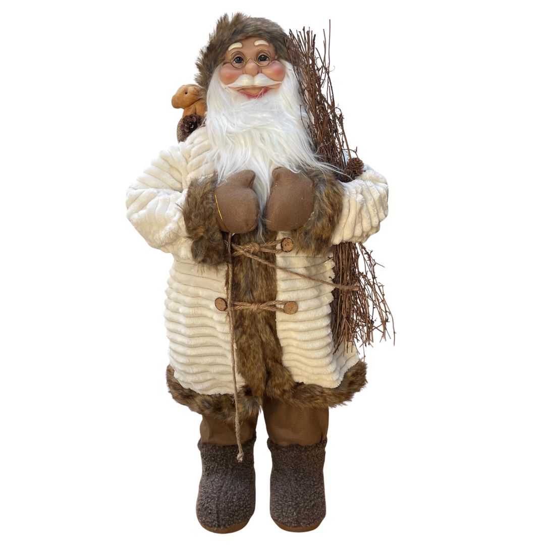 Figura decorativa di Babbo Natale in abiti invernali beige e marroni, con occhiali, barba bianca, sacco con orsacchiotto e fascina di rami in mano, alto 80cm.