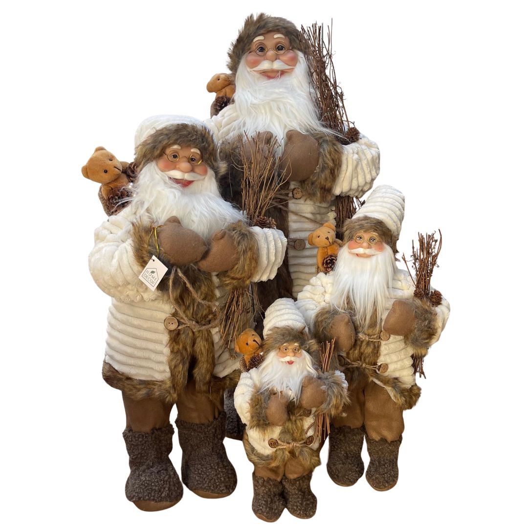 Insieme delle quattro figure di Babbo Natale in abiti invernali beige e marroni, con occhiali, barba bianca, sacco con orsacchiotto e fascina di rami in mano in diverse dimensioni.