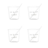 Set di quattro bicchierini in vetro trasparente con scritta bianca “un buon caffè” in stampatello e palettine incluse.