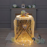 Allestimento interno su tavolo con fili della cascata 900 micro LED bianco caldo e flash LED bianco freddo.