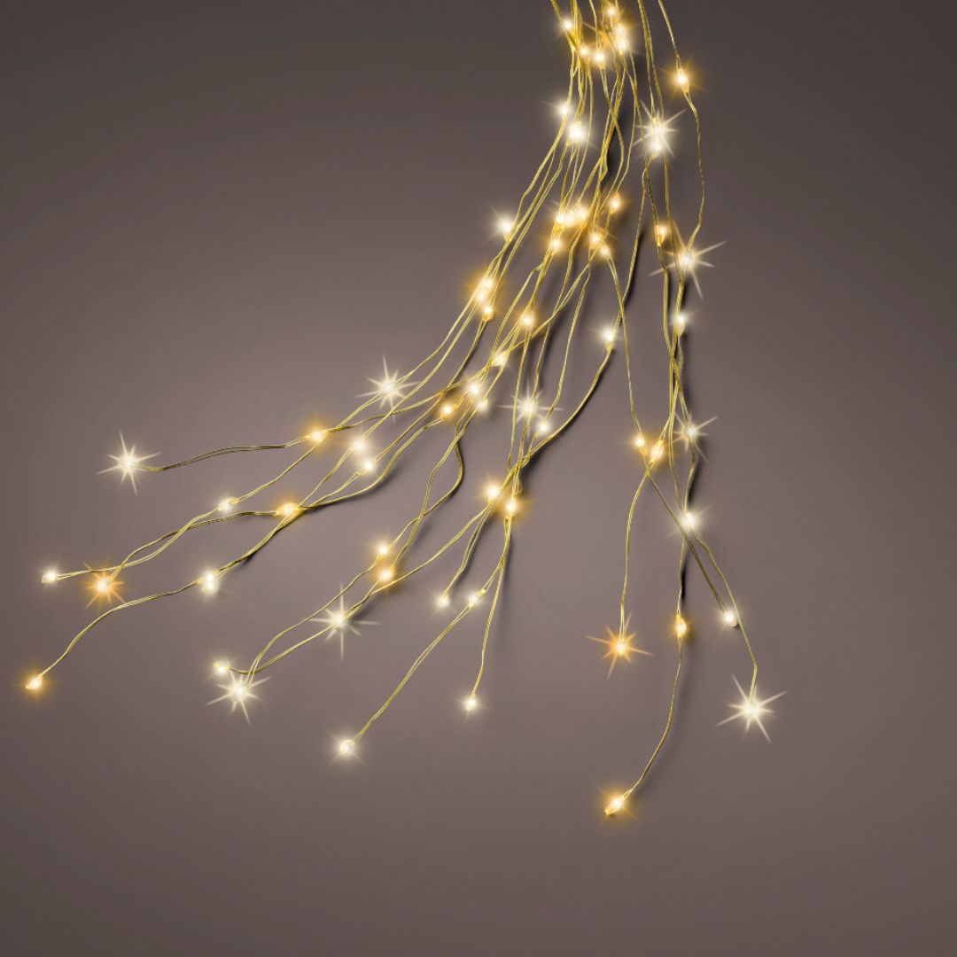 Cascata LED oro su sfondo scuro, fili sottili dorati con micro LED a luce calda e a luce tradizionale.