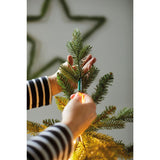 Mani che fissano l'elastico delle luci LED sulla punta dell’albero di Natale.