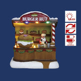 Casetta di vendita di hamburger con Babbo Natale e scritta "Burger Hut" su sfondo blu.