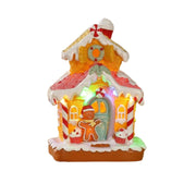 Casetta natalizia in stile gingerbread illuminata a LED, decorata con zuccherini, bastoncini di zucchero e omino pan di zenzero sulla porta.