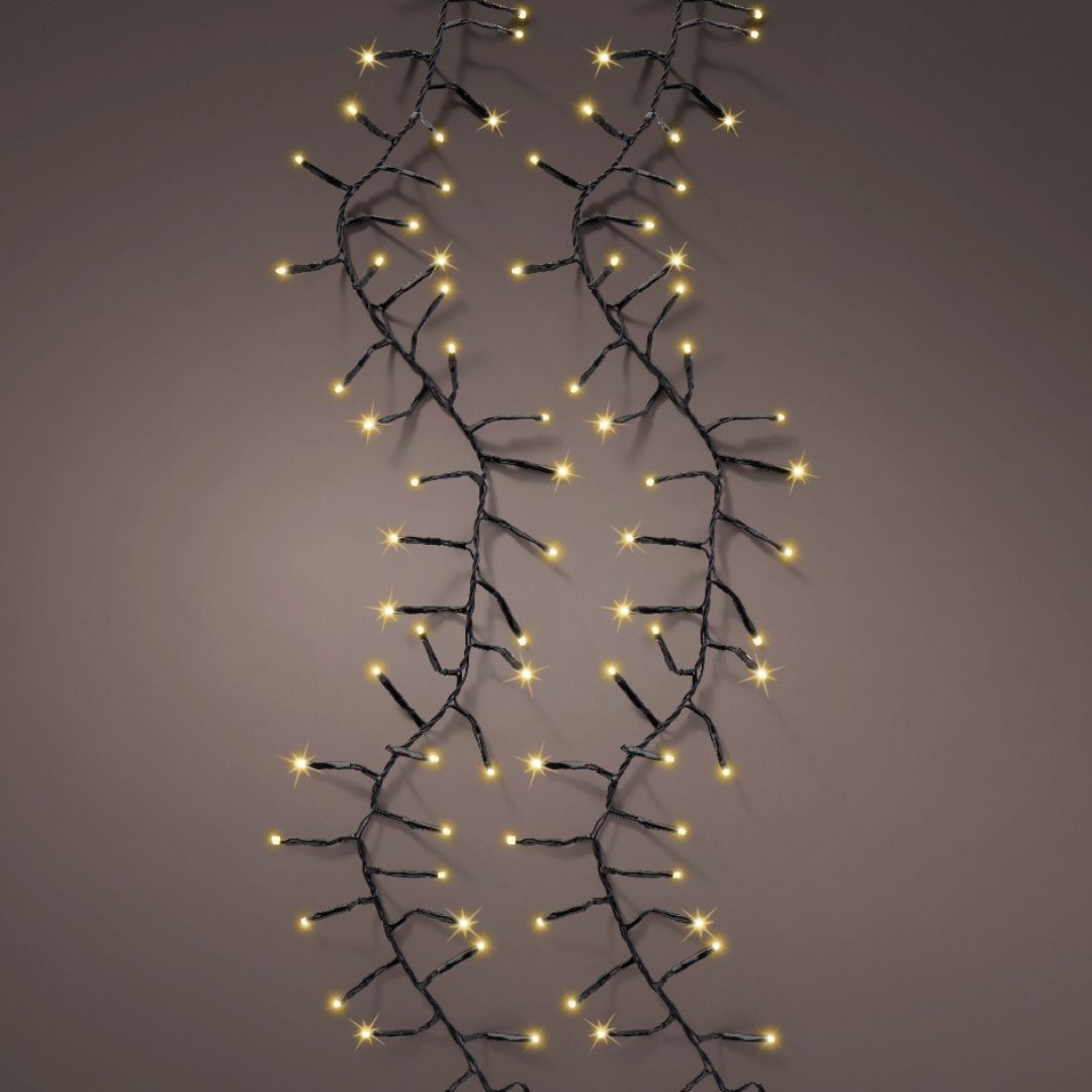 Catena luminosa da 2208 micro LED colore champagne con cavo nero su sfondo scuro.