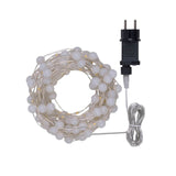Catena con micro LED alternati a piccole sfere di 1 cm di diametro con trasformatore su sfondo bianco.