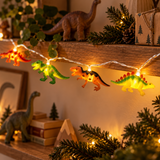 Catena luminosa con dinosauri illuminati ambientata tra decorazioni natalizie