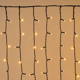 Dettaglio della tenda natalizia Ice Light con luci LED bianco caldo e fili verticali di diverse lunghezze.