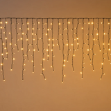 Tenda luminosa Ice Light accesa con fili pendenti irregolari e LED bianco caldo su cavo nero.