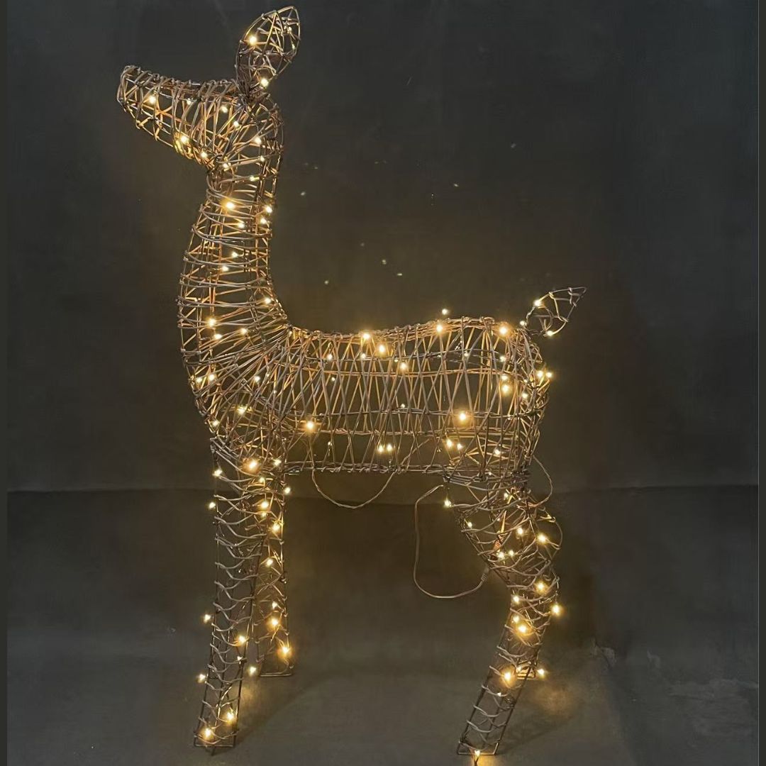 Figura natalizia a forma di cerbiatto in rattan con luci LED bianco caldo integrate nella struttura.
