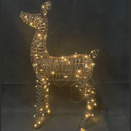 Figura natalizia a forma di cerbiatto in rattan con luci LED bianco caldo integrate nella struttura.