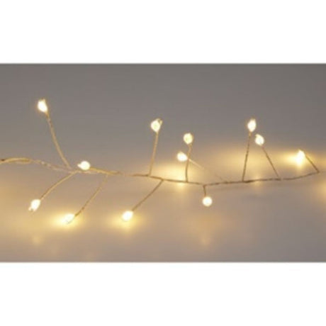 Filo luminoso cluster con micro LED a luce calda su cavo metallico argentato, acceso in ambiente neutro.
