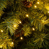 Dettaglio minicluster cavo verde LED bianco caldo tra rami di albero di Natale.