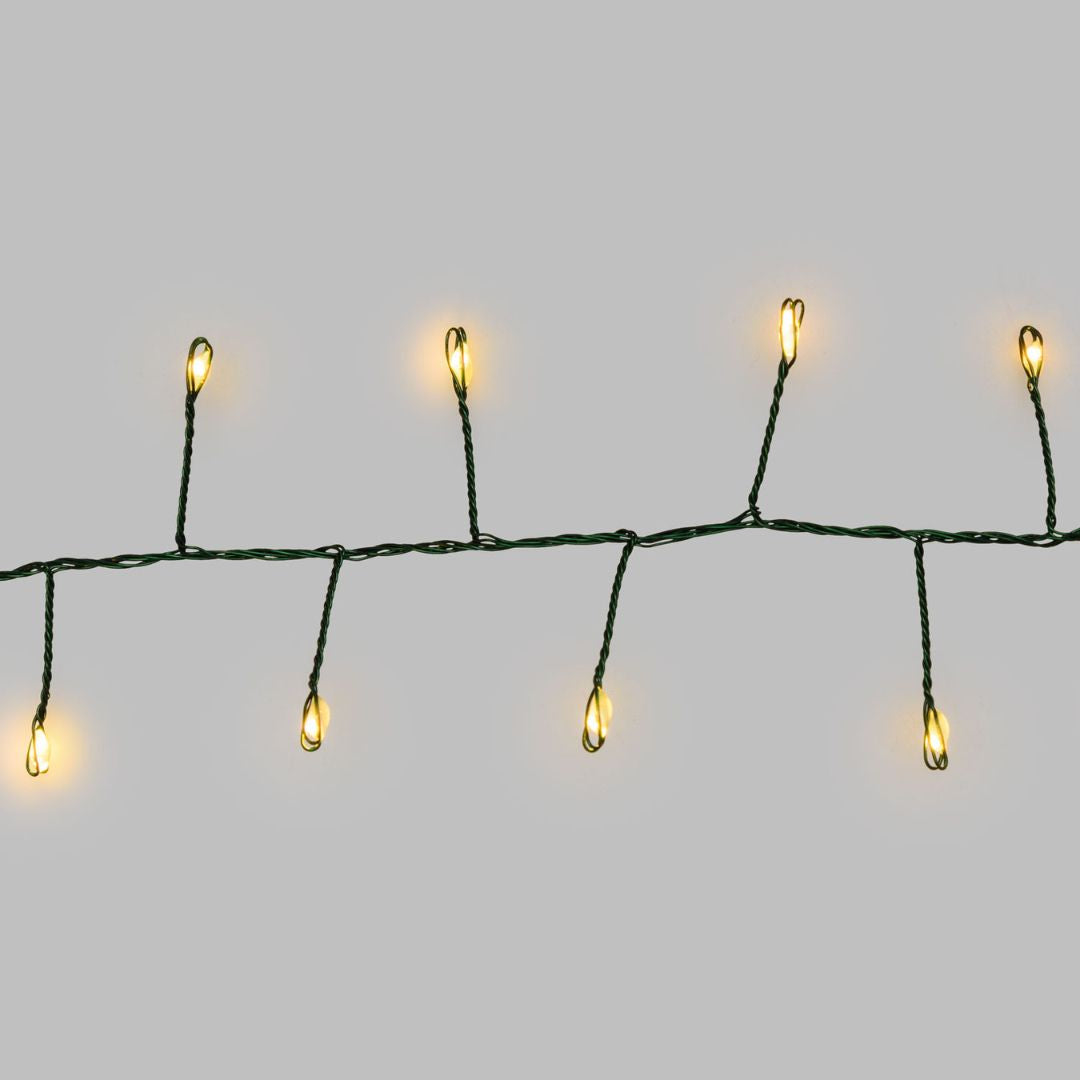 Micro LED a luce calda con cavo verde su sfondo grigio.