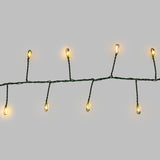 Micro LED a luce calda con cavo verde su sfondo grigio.