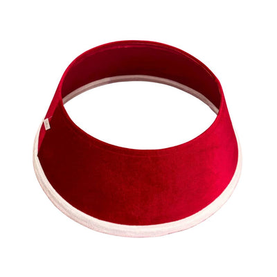 Copribase per albero di Natale in tessuto rosso con bordo in finta pelliccia bianco su sfondo bianco.