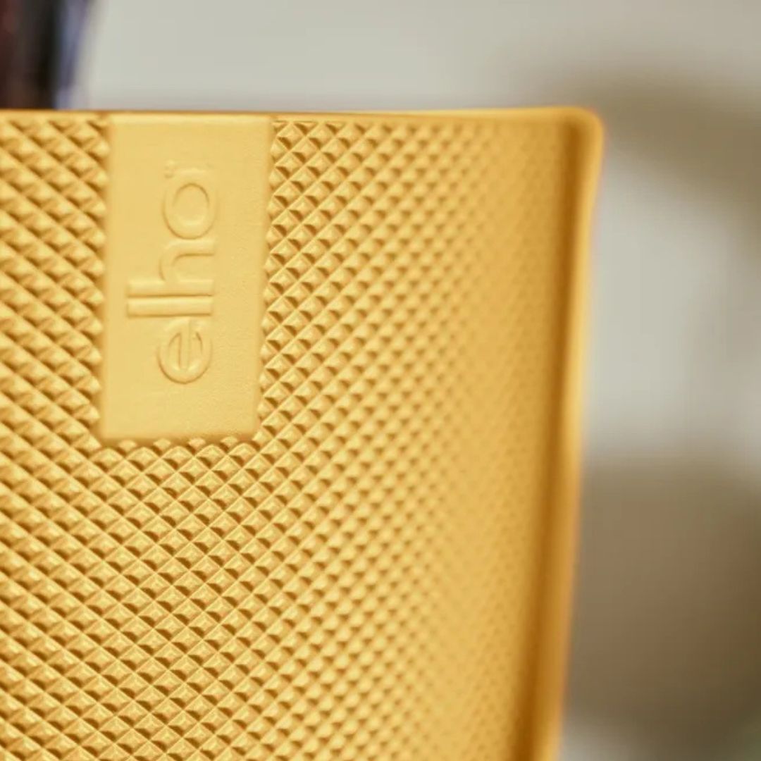 Dettaglio della texture del coprivaso giallo in plastica.