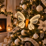 Farfalla Infinity luminosa bianca ambientata su un albero di Natale decorato con palline bianche e dettagli dorati