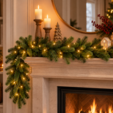 Festone natalizio verde con folti rami effetto abete e luci calde, disposto lungo il camino e inserito in un’elegante ambientazione natalizia con candele e decorazioni