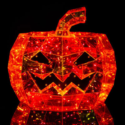 Figura a forma di zucca di Halloween dal volto intagliato, realizzata con superfici trasparenti arancioni illuminate da micro LED che creano un effetto iridescente.