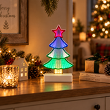 Albero di Natale Infinity multicolore illuminato, ambientato su un mobile tra luci e decorazioni natalizie