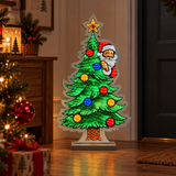 Albero di Natale luminoso con Babbo Natale ambientato in casa vicino all’ingresso, tra albero addobbato, luci e regali