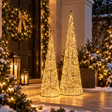 1. Coppia di coni natalizi dorati con micro LED a luce calda in un ingresso decorato