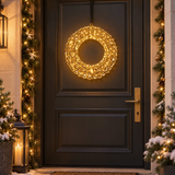 Corona natalizia riccio oro illuminata con micro LED, appesa alla porta d’ingresso