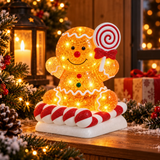 Pan di zenzero glitter LED con lecca-lecca ambientato tra decorazioni natalizie