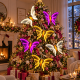 Farfalle Infinity luminose bianche, gialle e rosa su grande albero di Natale decorato con palline, fiocchi e luci calde