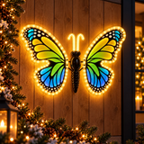 Farfalla LED gialla, verde e blu 40 cm ambientata su parete in legno