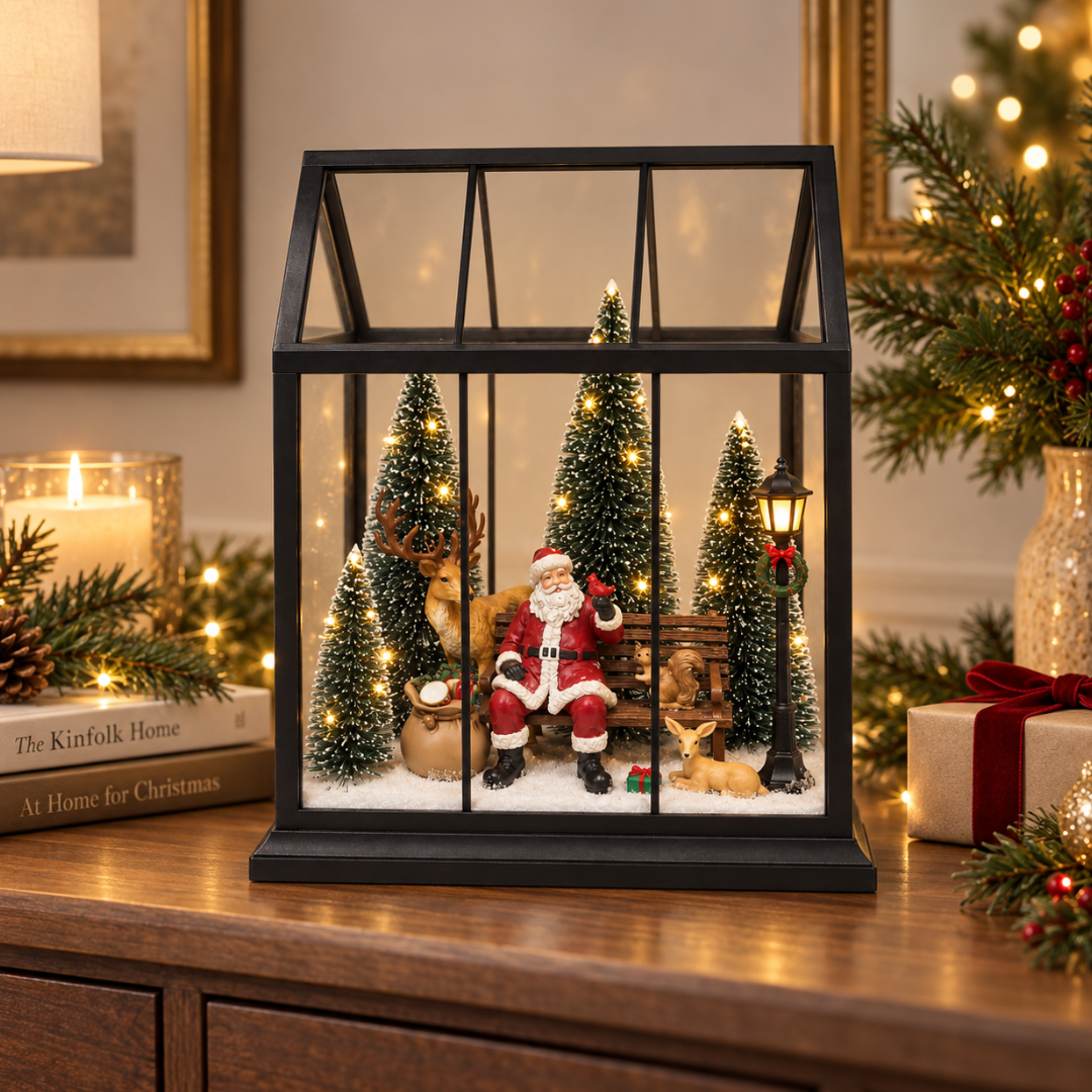 Lanterna natalizia con Babbo Natale e animali tra abeti illuminati, ambientata in una casa decorata per Natale