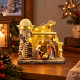 Presepe natalizio illuminato con Sacra Famiglia in una capanna rustica, ambientato su un tavolo con decorazioni di Natale