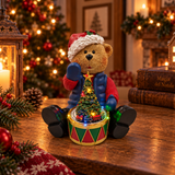 Orsetto natalizio con cappello di Babbo Natale e albero illuminato con trenino, ambientato su un tavolo con decorazioni di Natale