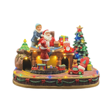 Decorazione natalizia illuminata con Babbo Natale, bambini, albero di Natale, regali e trenino alla base