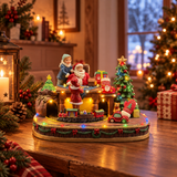 Decorazione natalizia illuminata con Babbo Natale e bambini, albero di Natale, regali, trenino e automobilina, ambientata su un tavolo