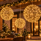 Tre sfere luminose sospese di diverse dimensioni con micro LED a luce calda in ambientazione natalizia