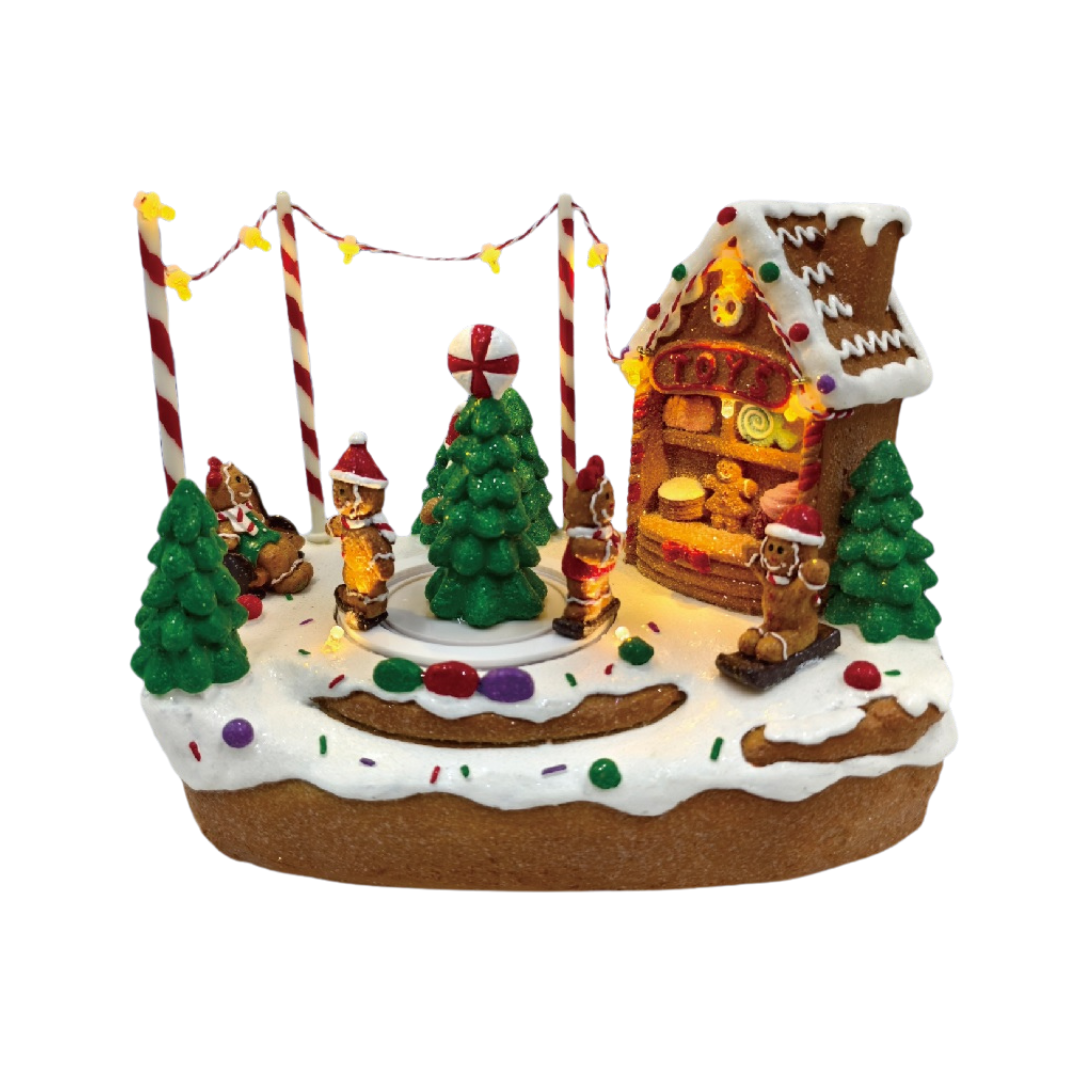 Villaggio natalizio a tema pan di zenzero illuminato con casetta, albero decorato, personaggi e dolci su paesaggio innevato